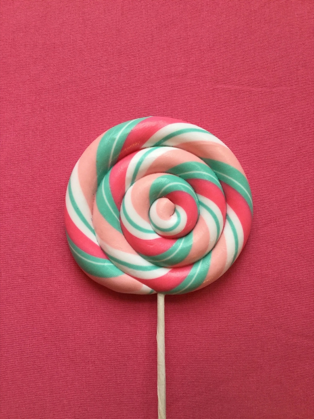 Pastel pink and teal swirled candy — freshly spun sweetness