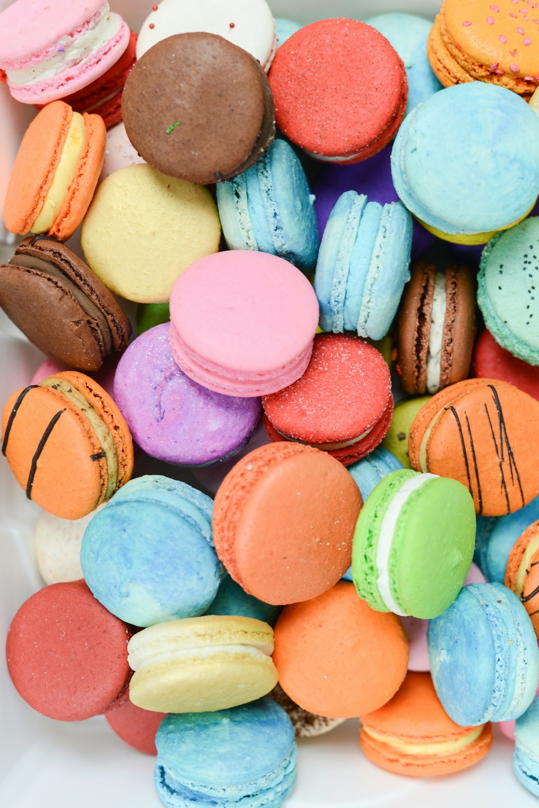 A rainbow pile of pastel macarons — the kind of sweet moment Candi loves to bring to a party